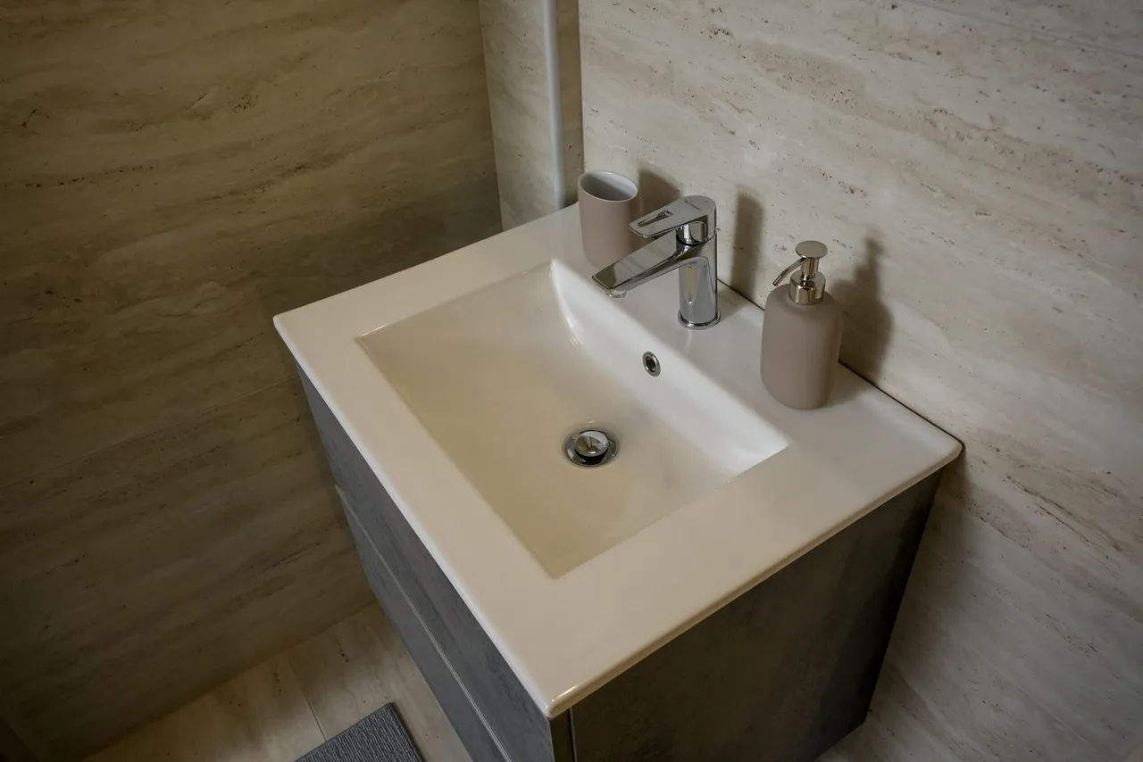 Basin and stone wall detail in bathroom one