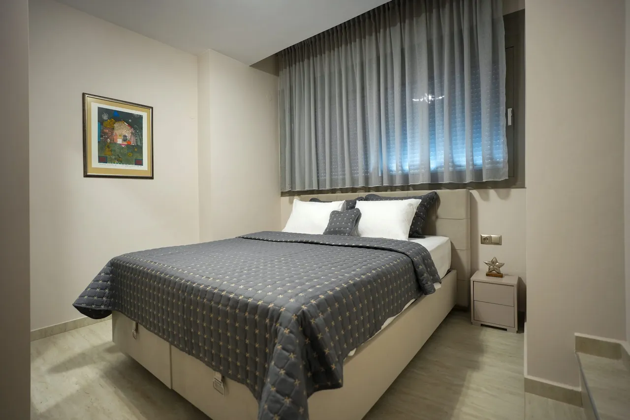 Wide view of bedroom one with soft natural light
