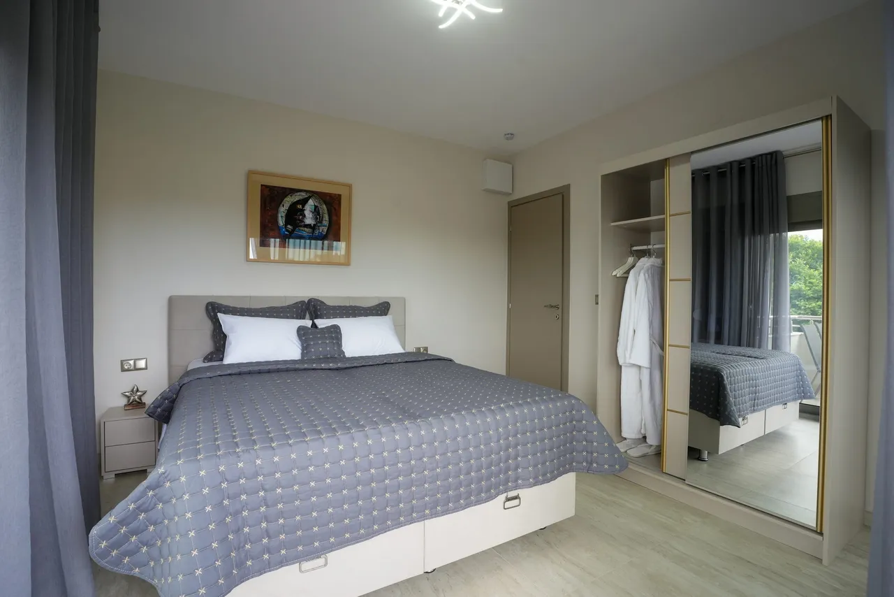 Bedroom two with mirrored wardrobe and balcony access